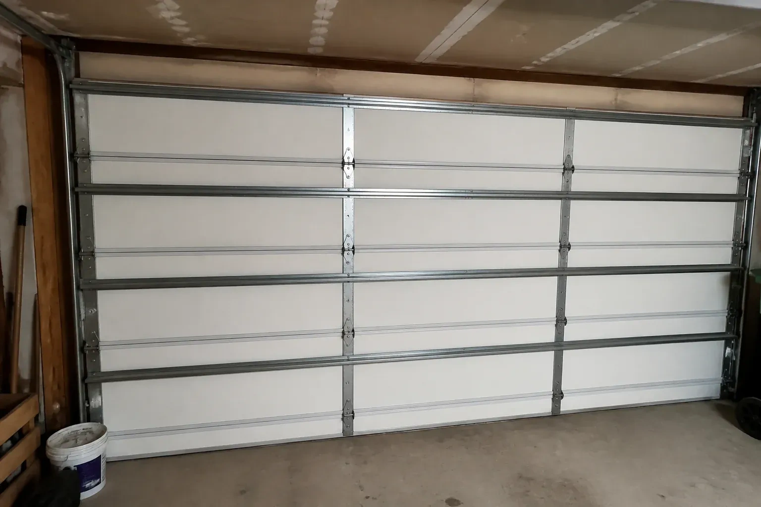 Interior of a closed sectional door with horizontal metal reinforcement struts. — Wind-Rated Garage Door Replacement, Brampton